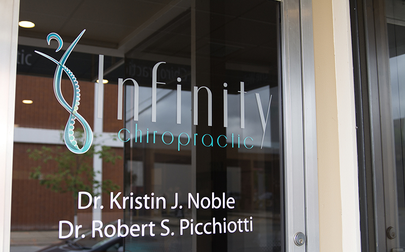 Door signage of Infinity Chiropractic & Wellness Center in downtown Winona, Minnesota.