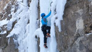 ice climber scales a rock and ice wall