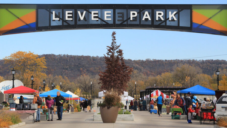 The entrance of levee park in Winona with a bustling farmers market inside the park
